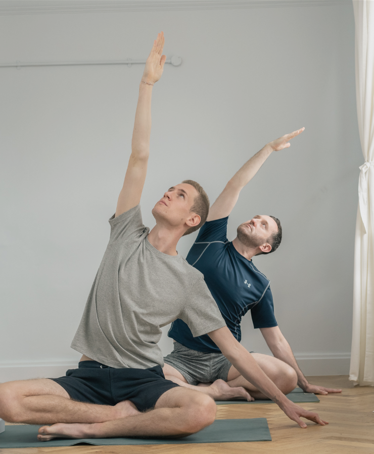 men in sitting yoga pose stretching arm over head